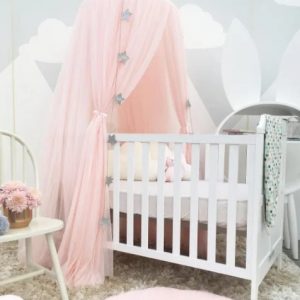 Ciel de lit en tulle rose claire dans une chambre d'enfant